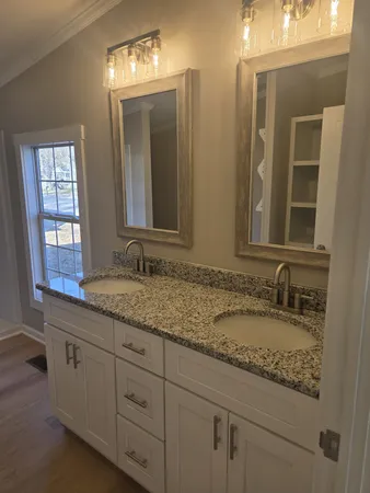 a bathroom with double sink and a mirror