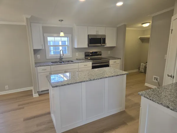 a kitchen with stainless steel appliances granite countertop a stove a sink and a microwave