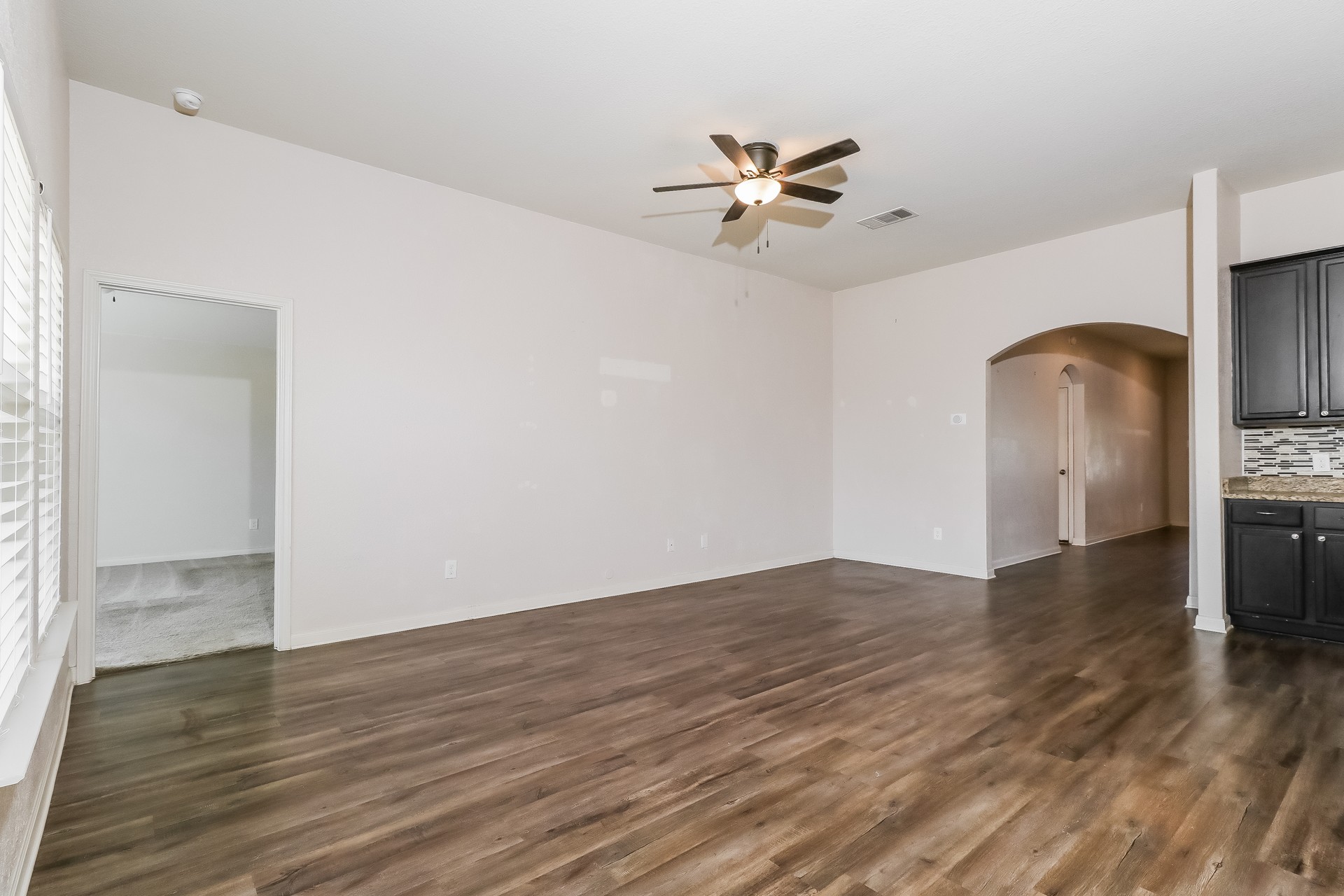 20017 Hubert R Humphrey Road Manor, TX 78653 - Photo 3 of 27 A well-lit living area features rich wood flooring and a refreshing ceiling fan.