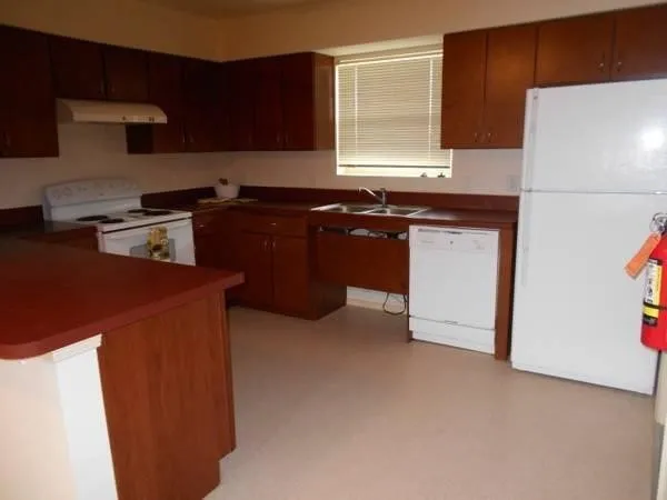 a kitchen with stainless steel appliances granite countertop a sink and a refrigerator