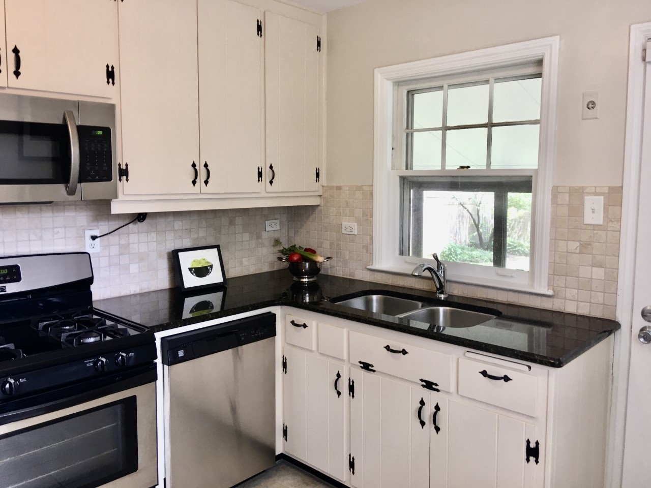 719 North County Line Road Hinsdale, IL 60521 - Photo 5 of 12 a kitchen with granite countertop white cabinets and black appliances