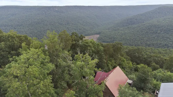 a aerial view of a house with a yard and mountain view