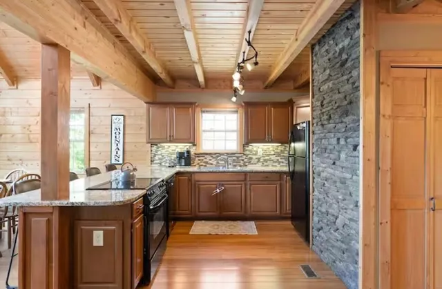a large kitchen with kitchen island granite countertop a large window