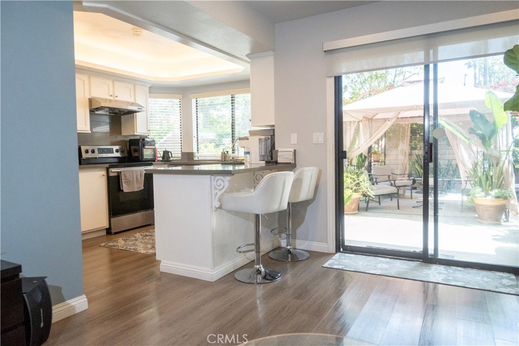 1320 Zeus West Covina, CA 91790 - Photo 12 of 39 a dining hall with stainless steel appliances granite countertop a stove a refrigerator a sink a dining table and chairs with wooden floor