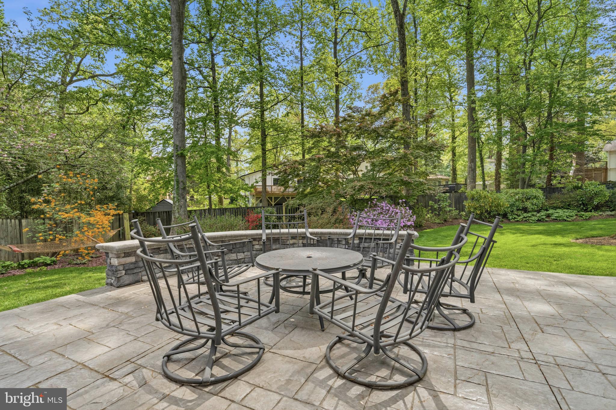 8927 Cromwell Drive Springfield, VA 22151 - Photo 11 of 20 a view of a backyard with table and chairs and a barbeque with potted plants and big trees