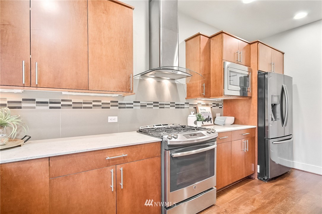 5113 Northeast 11th Place Renton, WA 98059 - Photo 15 of 40 a kitchen with stainless steel appliances granite countertop a stove a sink and a refrigerator