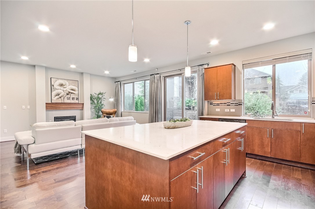 5113 Northeast 11th Place Renton, WA 98059 - Photo 16 of 40 a view of kitchen island a sink and living room with a large window