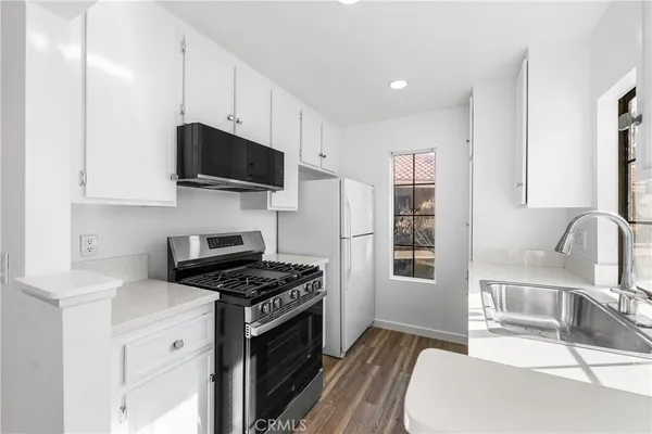 a kitchen with stainless steel appliances a stove a sink a microwave and cabinets