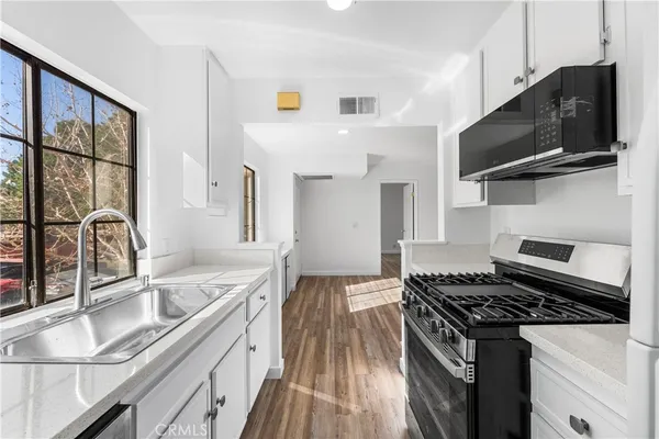 a kitchen with stainless steel appliances granite countertop a stove and a sink