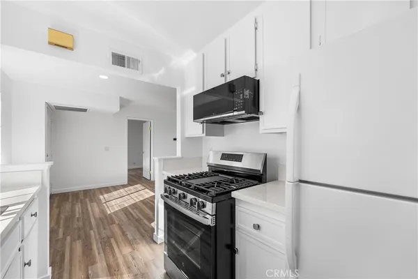 a kitchen with stainless steel appliances white cabinets and a stove