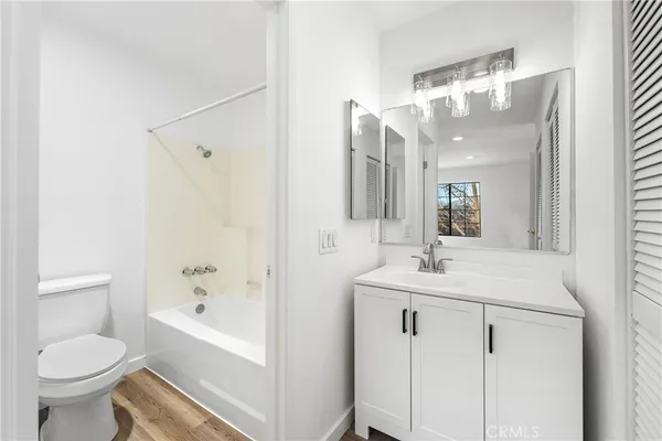 a bathroom with a sink toilet vanity and shower