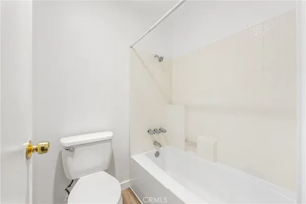 a white toilet sitting next to a bath tub