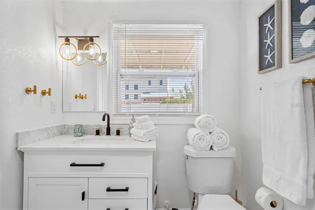 a bathroom with a sink a toilet and a window