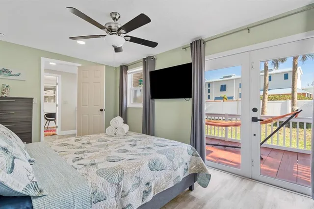 a bedroom with a large bed a flat tv screen and a dresser