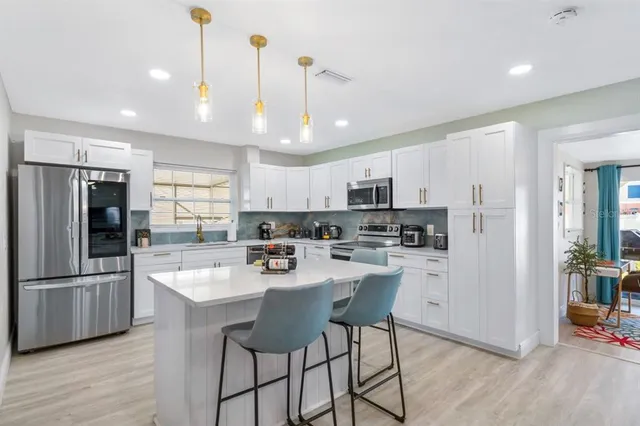 a kitchen with stainless steel appliances a refrigerator sink and microwave