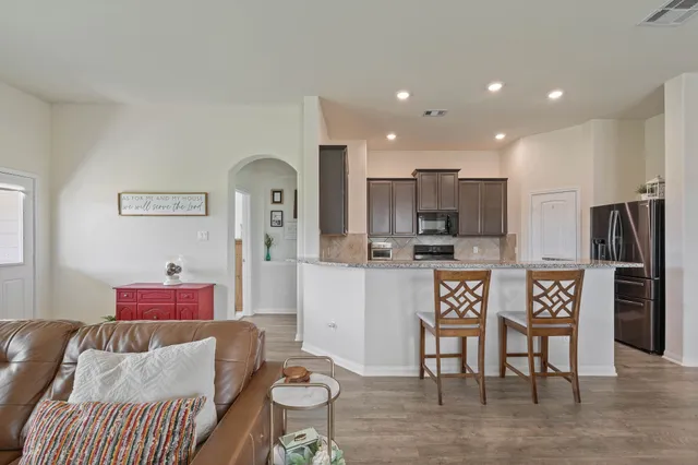 a view of a dining room with furniture a kitchen and chandelier