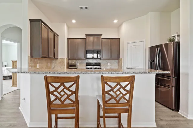 a living room with stainless steel appliances kitchen island granite countertop furniture and a view of kitchen