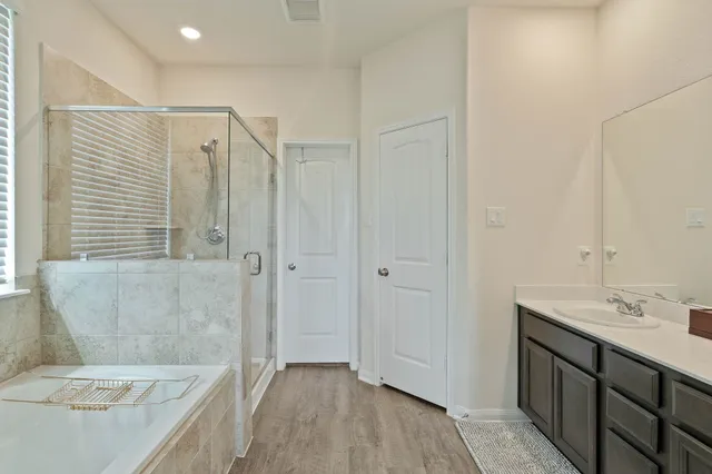 a spacious bedroom with a large bed and a chandelier