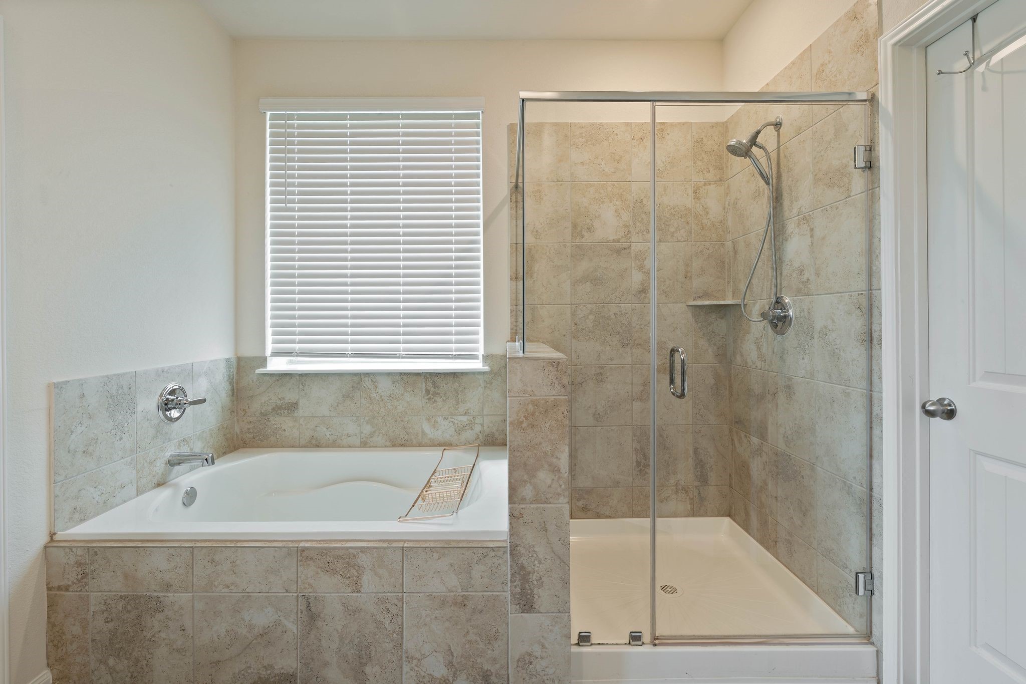 16450 Stonewall Street Conroe, TX 77303 - Photo 21 of 43 Close-up of the primary bath with tiled shower and separate soaking tub.