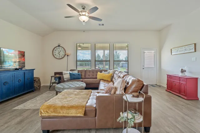 a living room with furniture and a wooden floor