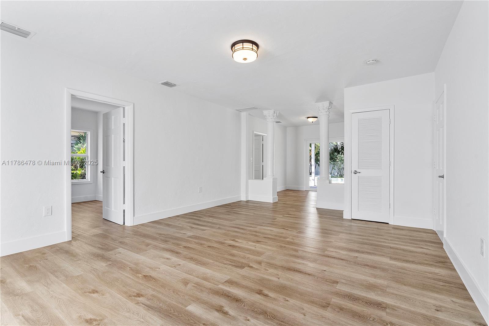 8934 Harding Avenue Surfside, FL 33154 - Photo 11 of 52 a view of an empty room with wooden floor and a ceiling fan