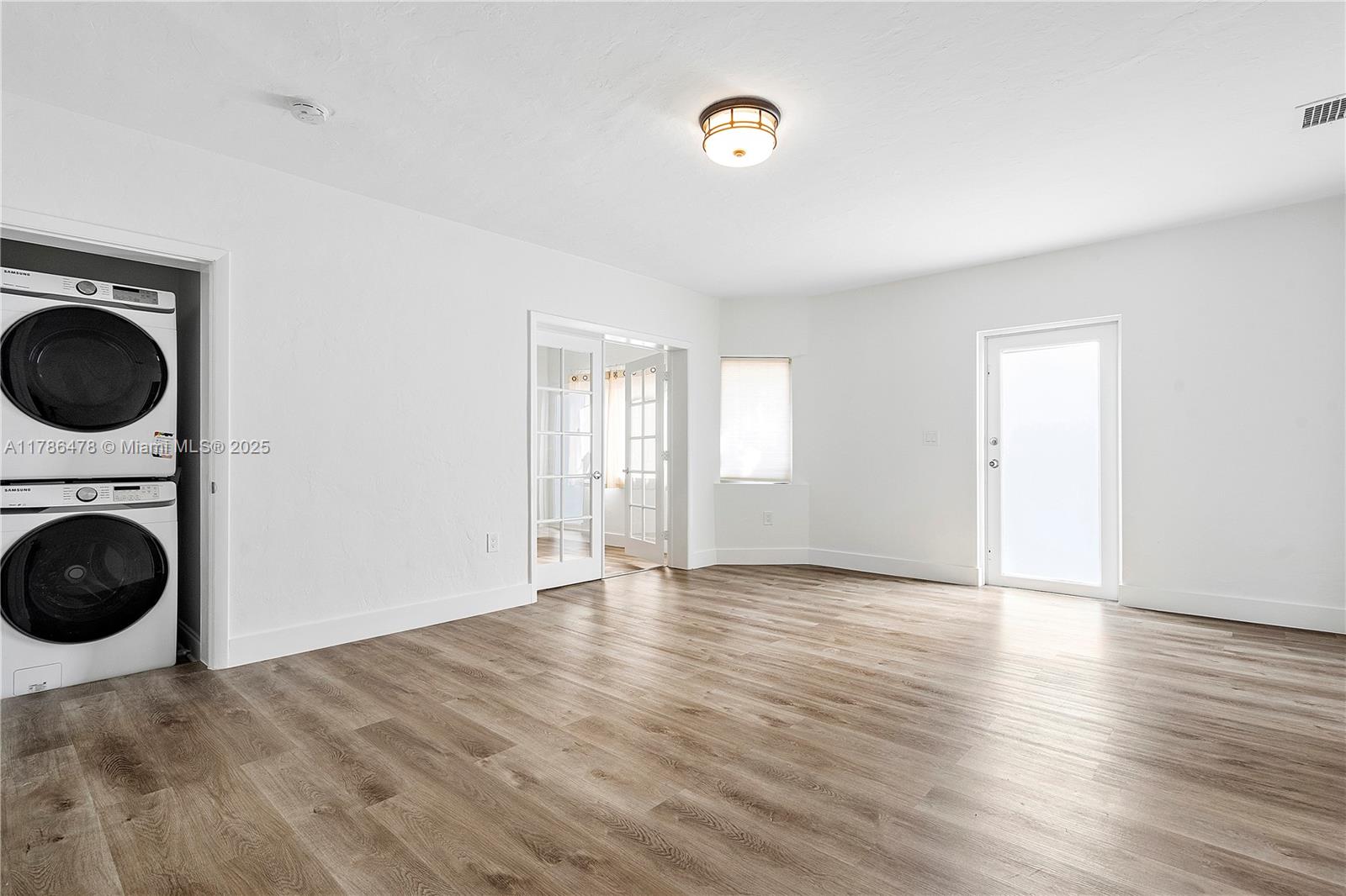 8934 Harding Avenue Surfside, FL 33154 - Photo 14 of 52 a view of an empty room with a window and wooden floor