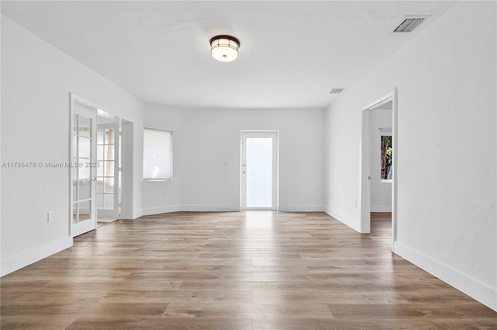 8934 Harding Avenue Surfside, FL 33154 - Photo 15 of 52 a view of an empty room with window and wooden floor