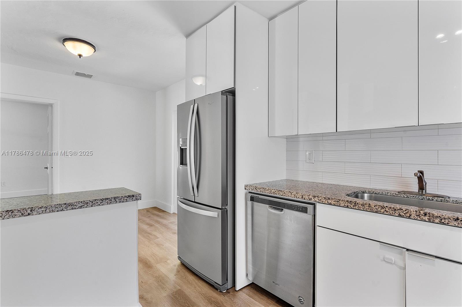 8934 Harding Avenue Surfside, FL 33154 - Photo 25 of 52 a kitchen with granite countertop cabinets and refrigerator