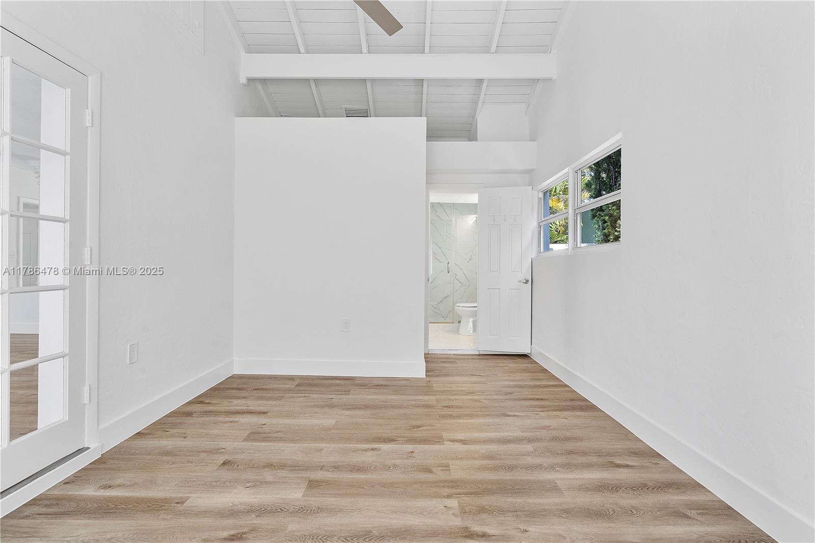8934 Harding Avenue Surfside, FL 33154 - Photo 28 of 52 a view of an empty room with wooden floor and a window