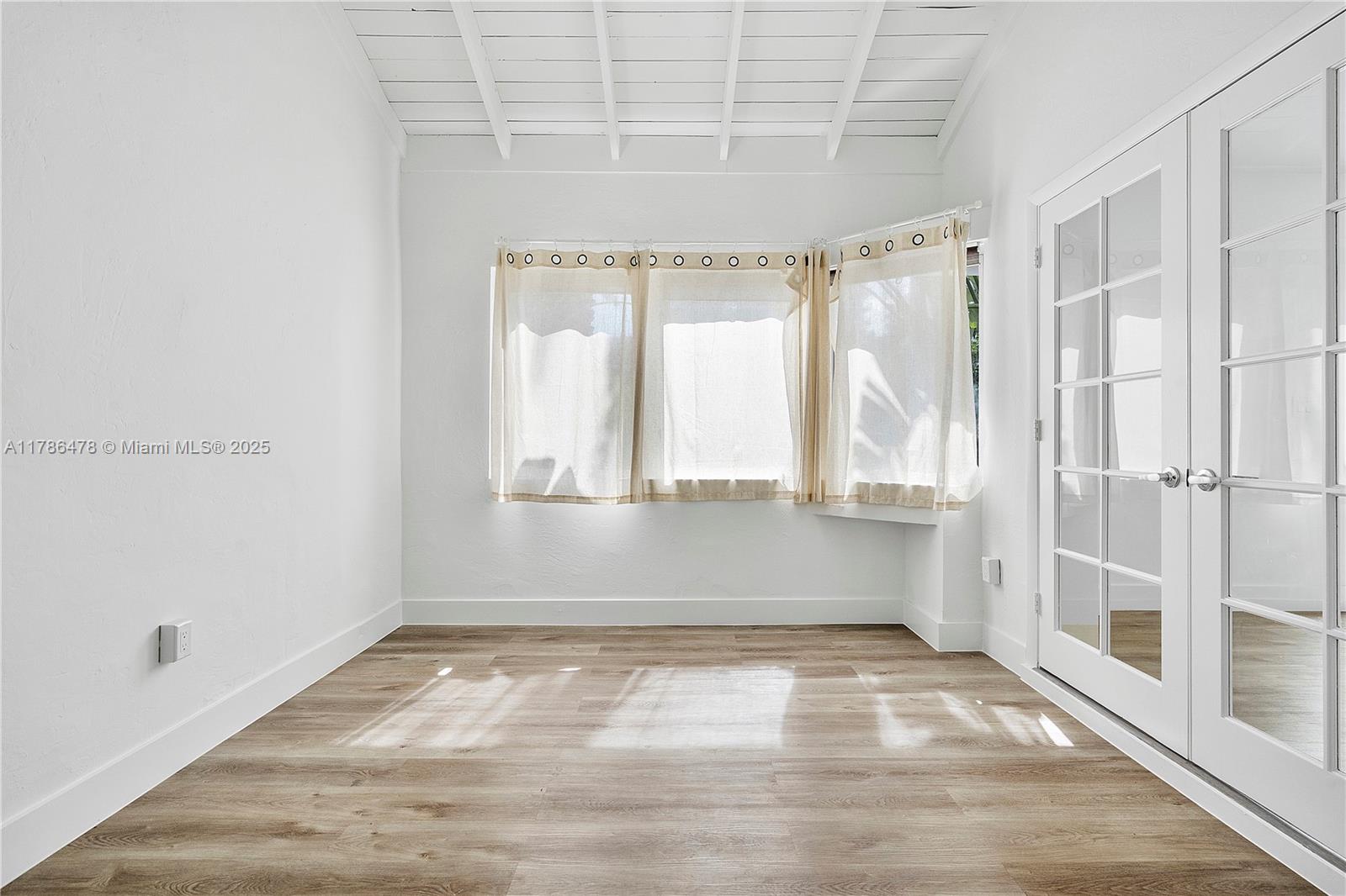 8934 Harding Avenue Surfside, FL 33154 - Photo 29 of 52 a view of room with window and hardwood floor