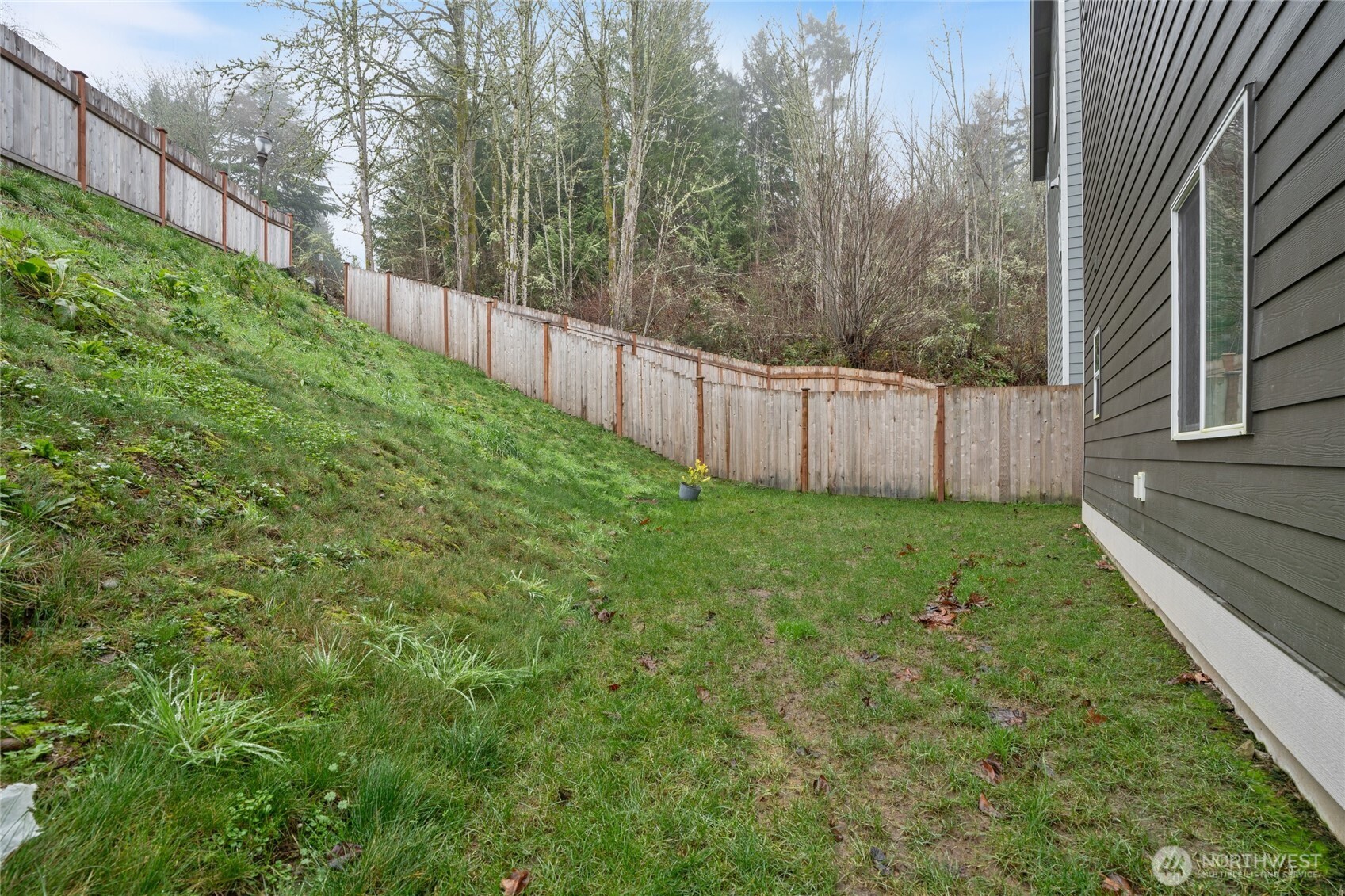 138 Blackfish Court Bremerton, WA 98310 - Photo 28 of 36 a view of a backyard with large trees and wooden fence
