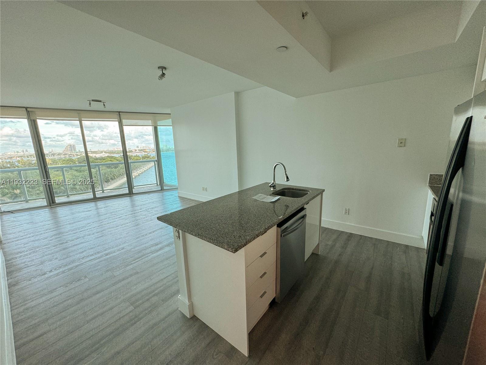 888 Biscayne Boulevard, Unit 709 Miami, FL 33132 - Photo 11 of 48 a kitchen with a wooden floor and large window