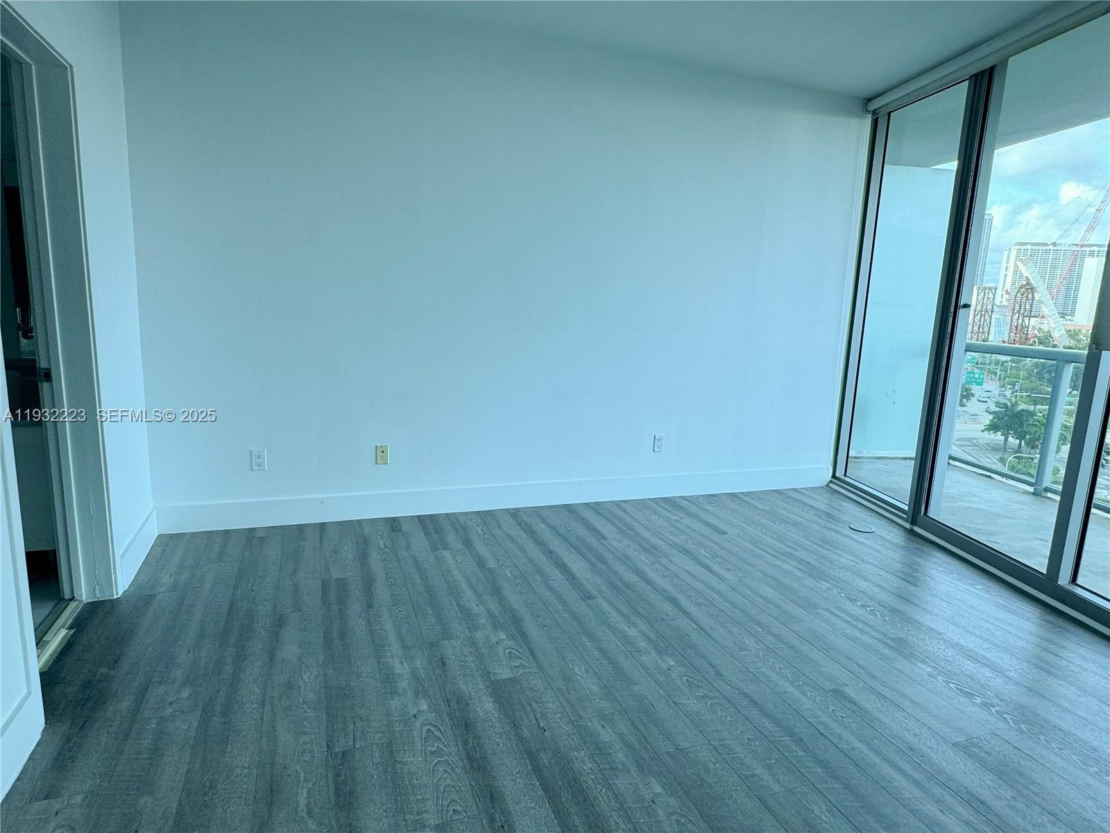 888 Biscayne Boulevard, Unit 709 Miami, FL 33132 - Photo 22 of 48 an empty room with wooden floor and windows