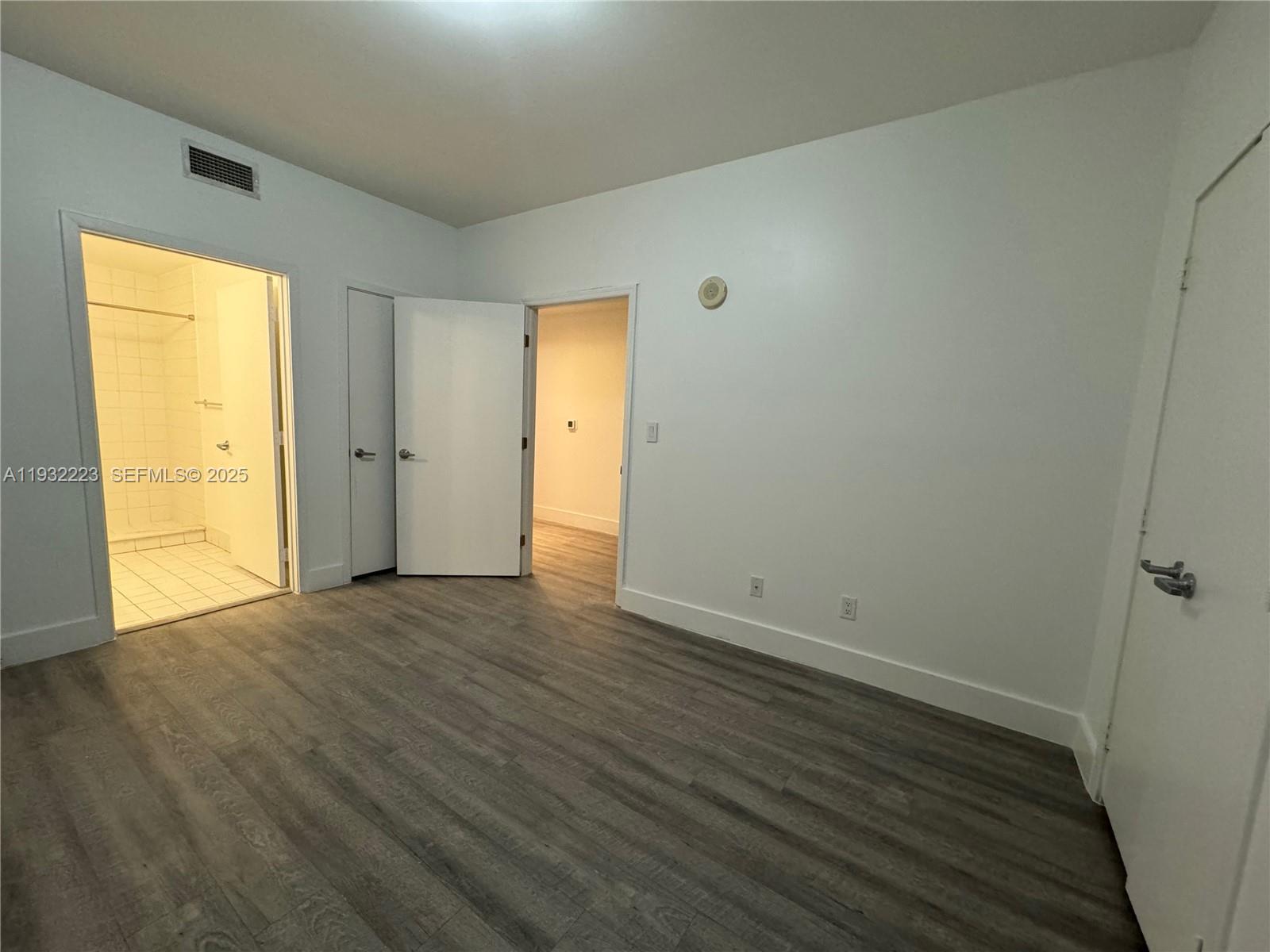 888 Biscayne Boulevard, Unit 709 Miami, FL 33132 - Photo 28 of 48 a view of an empty room with wooden floor and a window