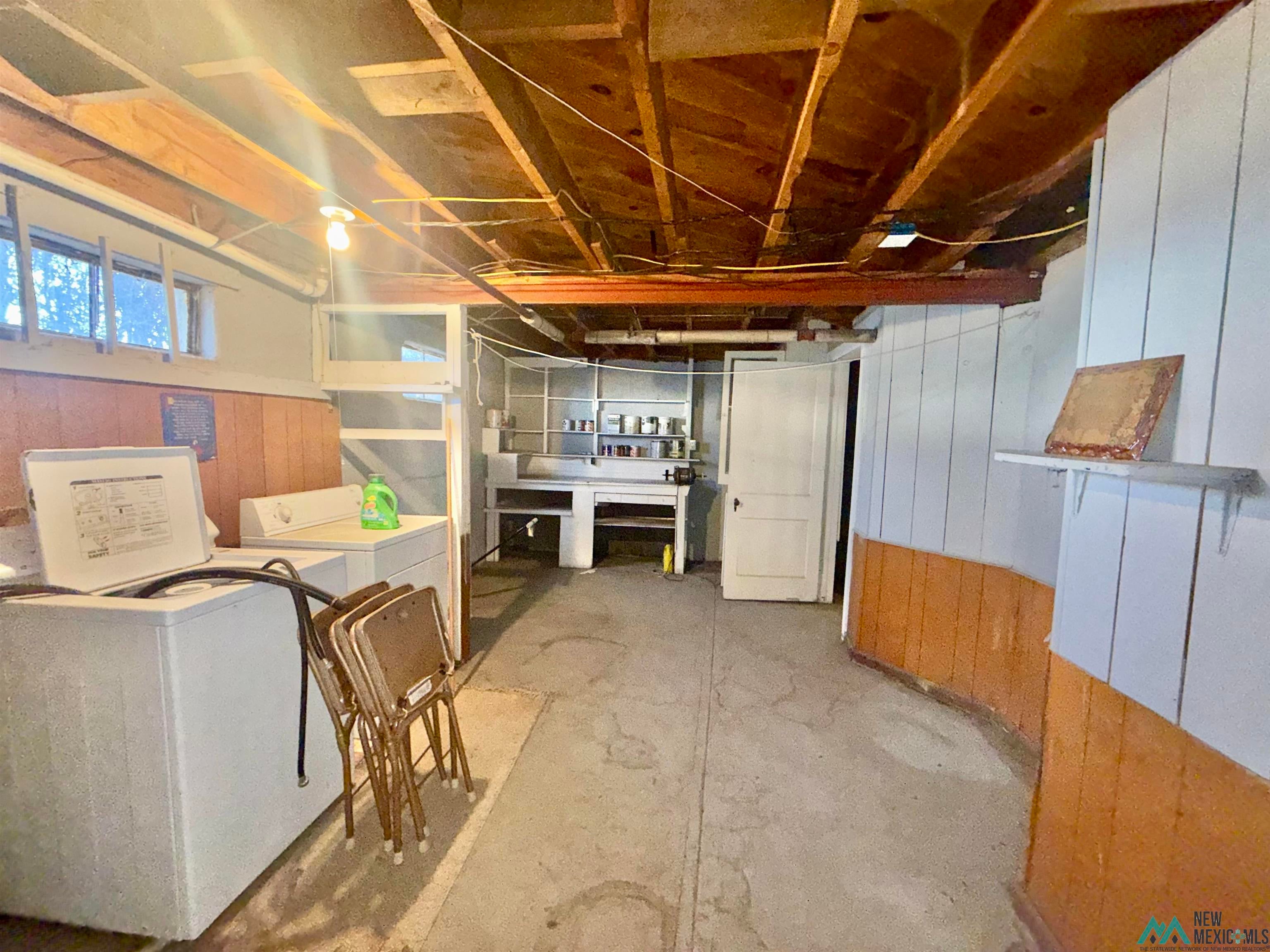 904 South 4th Street Raton, NM 87740 - Photo 17 of 19 Below grade area with wooden walls and washer and clothes dryer