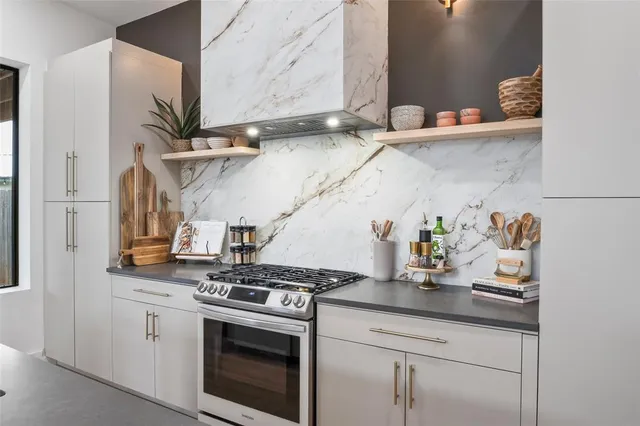 a kitchen with stainless steel appliances granite countertop a sink a stove and a microwave