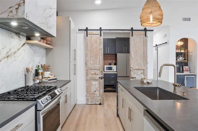 a kitchen with stainless steel appliances a refrigerator and a cabinets