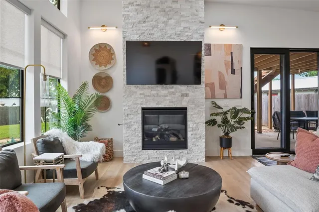 a living room with furniture a fireplace and a floor to ceiling window