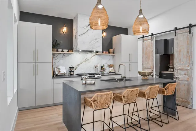 a kitchen with stainless steel appliances granite countertop a sink and a refrigerator