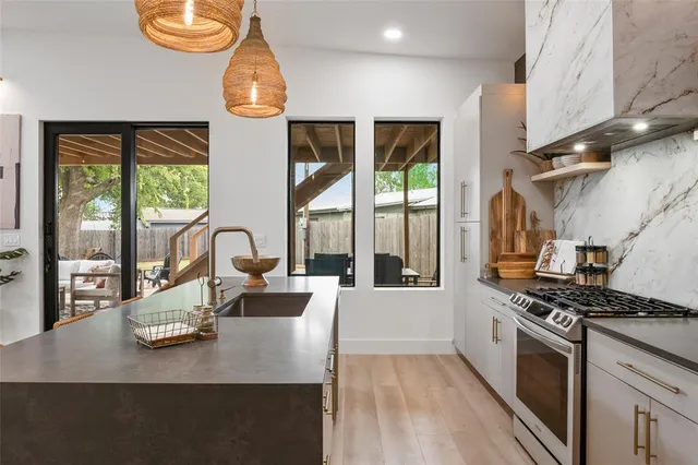 a kitchen with stainless steel appliances granite countertop a sink stove and refrigerator