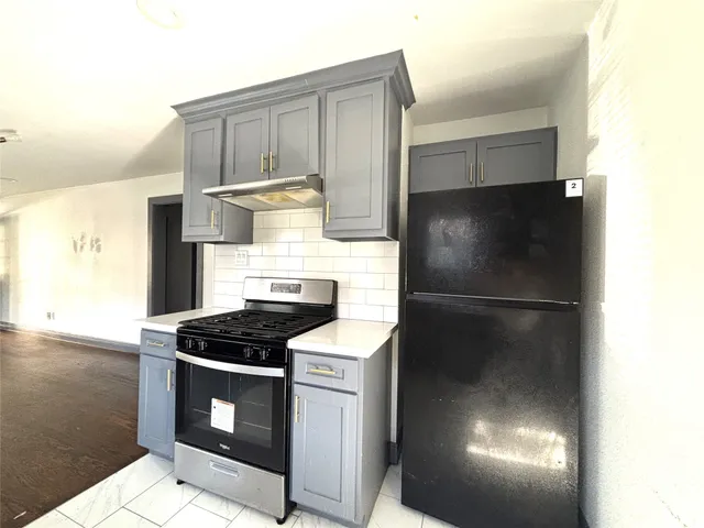 a kitchen with stainless steel appliances granite countertop a refrigerator a stove and a sink with granite countertops