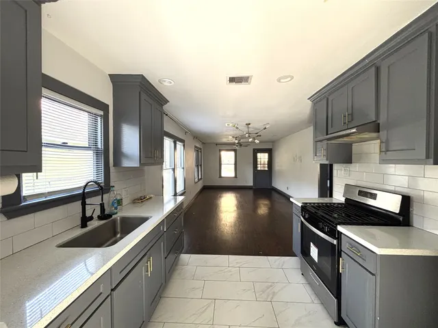 a kitchen with stainless steel appliances granite countertop a sink stove and cabinets