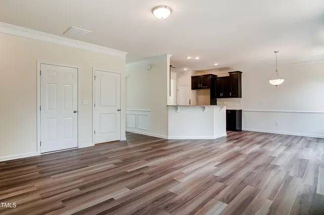 a view of empty room with wooden floor and window
