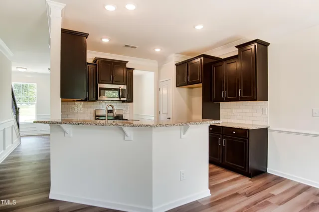 a kitchen with stainless steel appliances granite countertop a stove a sink and a microwave
