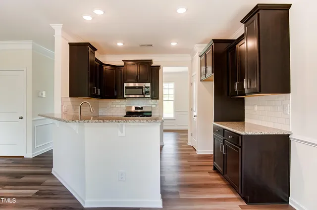 a kitchen with stainless steel appliances granite countertop a refrigerator and a stove top oven