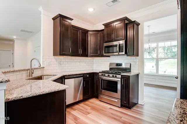 a kitchen with stainless steel appliances granite countertop a stove microwave and sink