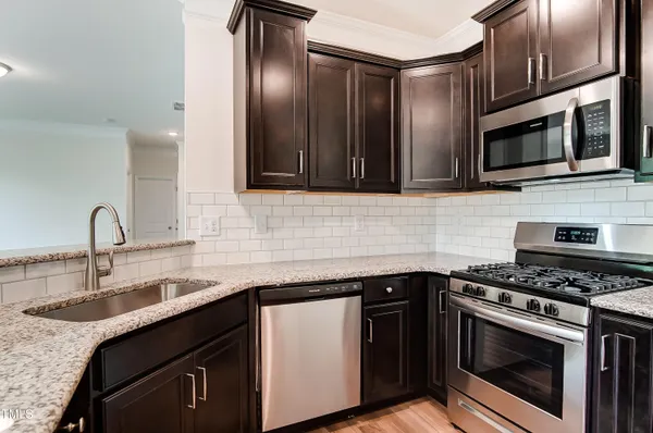 a kitchen with stainless steel appliances granite countertop a sink stove and microwave