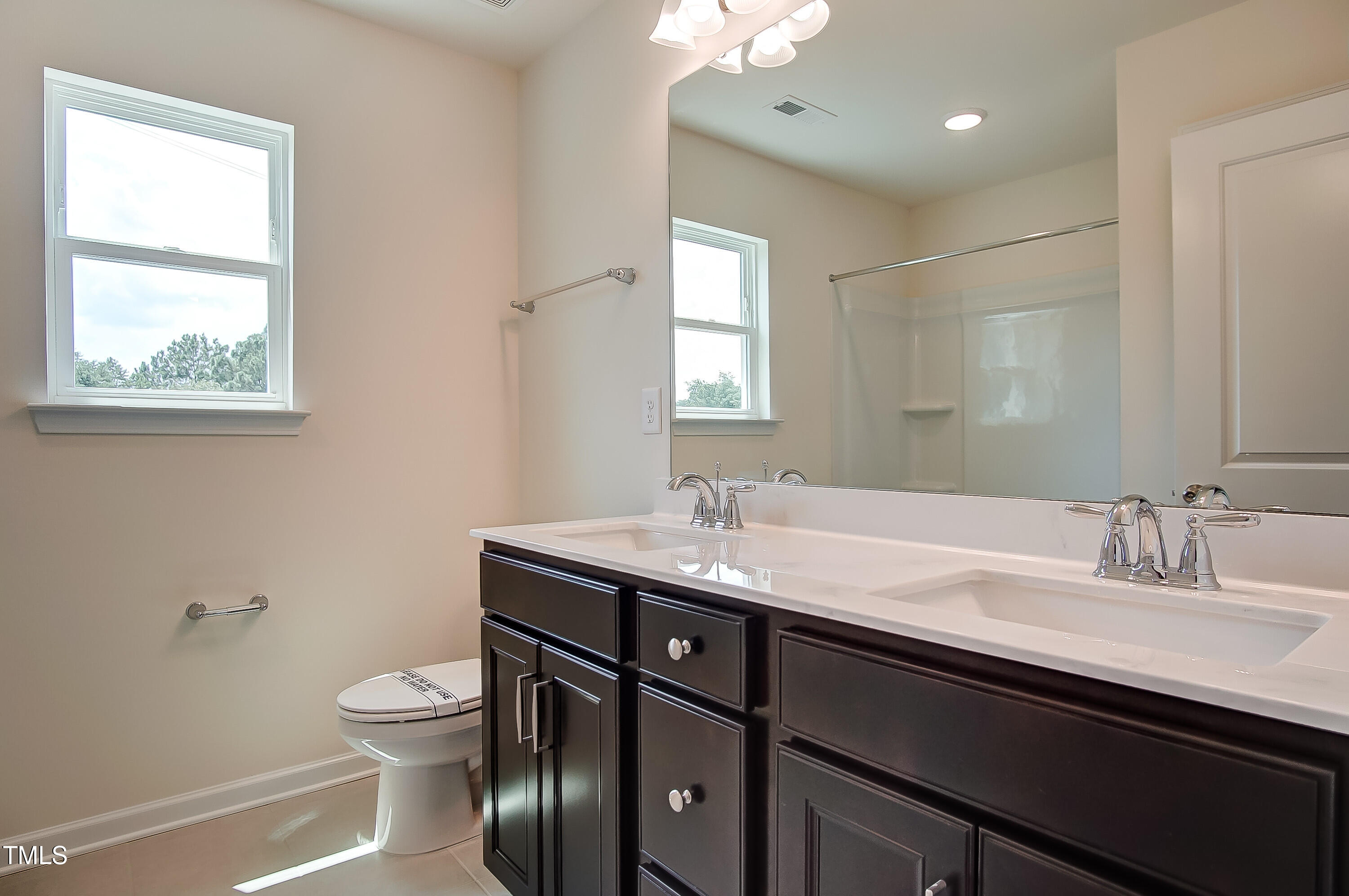0 Sawmill Road Hillsborough, NC 27278 - Photo 36 of 49 a bathroom with a granite countertop sink a toilet a mirror and a window