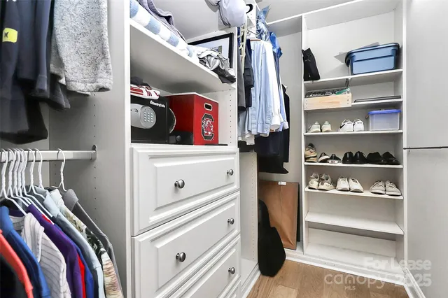 a view of walk in closet with clothes and shoes