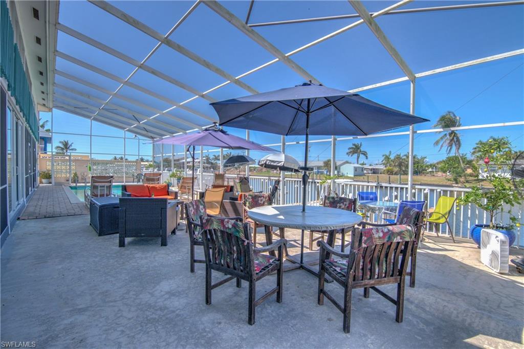 3215 Stringfellow Road, Unit 2A St. James City, FL 33956 - Photo 17 of 31 a view of a patio with table and chairs under an umbrella